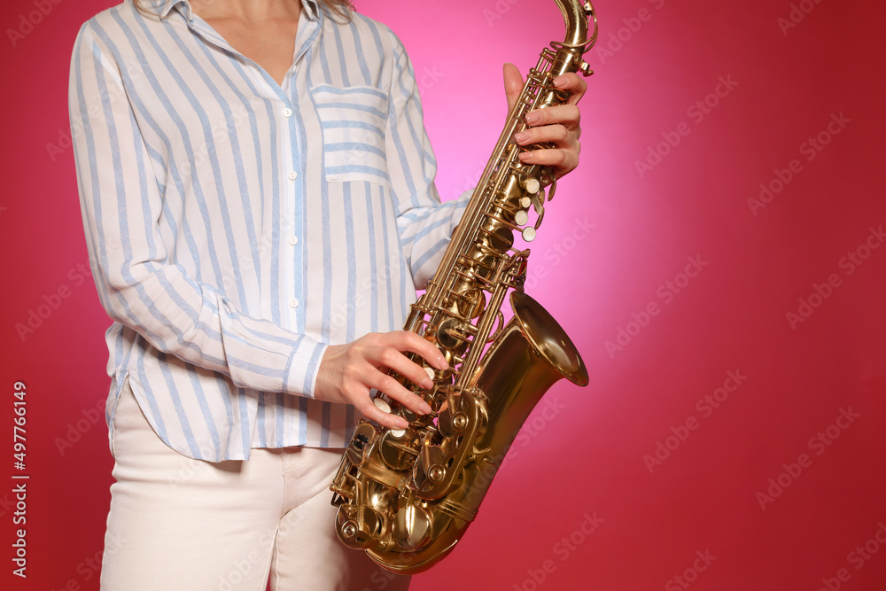 Naklejka premium Woman with saxophone on red background, closeup. Space for text