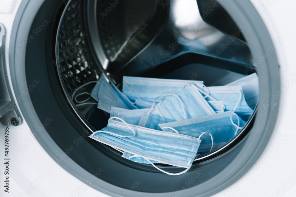 Medical masks in washing machine. Washing machine loading Medical masks in washing machine. Washing machine loading