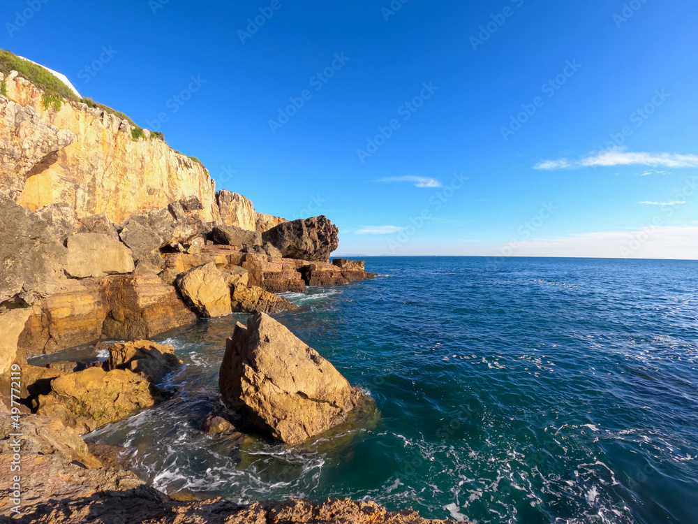 Cliffs with fallen rock cliff and formations of Cabo da Guia, next to Cascais and Lighthouse Farol da Guia, Lisbon, Portugal