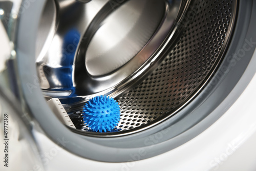 Blue dryer ball in washing machine drum, closeup
