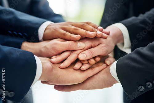 Success and solidarity. Closeup shot of a group of businesspeople standing in a huddle with their hands stacked together.