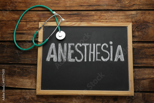 Bild auf Leinwand Blackboard with word Anesthesia and stethoscope on wooden table, top view