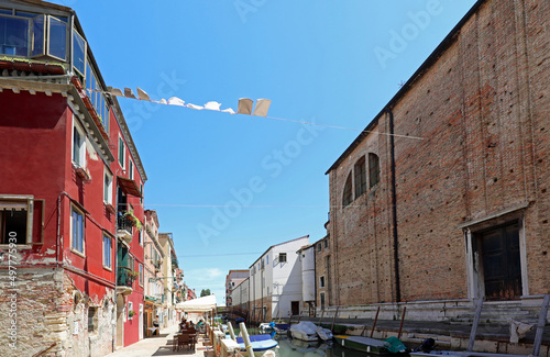 washing lines between a church and houses with clothes over the navigable canal in Venice Island