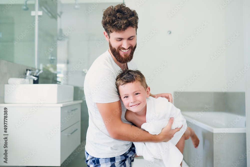 Fototapeta premium Having a little fun drying off. Cropped shot of a young handsome father drying his adorable little son after a bath in the bathroom at home.