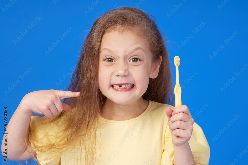Toothless child. Cute little girl smiles broadly with a toothbrush in hand. The first milk tooth fell out. The concept of pediatric dentistry and dental hygiene Toothless child. Cute little girl smiles broadly with a toothbrush in hand. The first milk tooth fell out. The concept of pediatric dentistry and dental hygiene