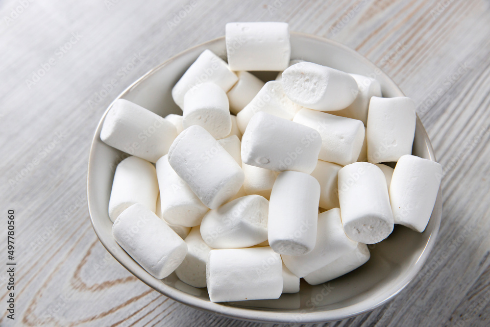 White marshmallows in a porcelain bowl on the table White marshmallows in a porcelain bowl on the table