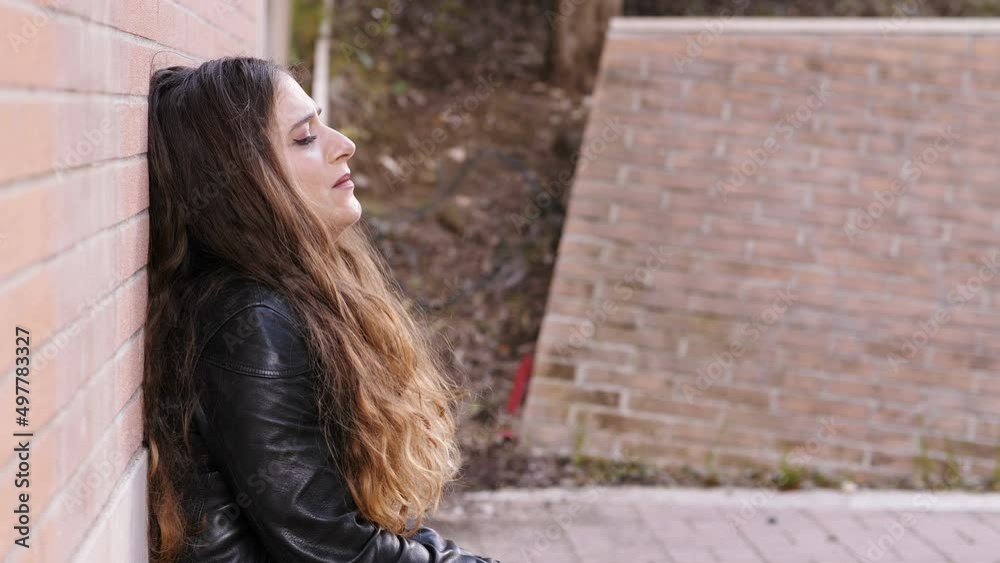 sadness, depression - distressed woman leaning against a wall cries sadness, depression - distressed woman leaning against a wall cries