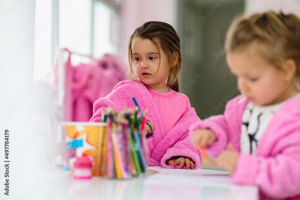 Little girls having fun in spa while drawing and eating popcorn. Little girls having fun in spa while drawing and eating popcorn.