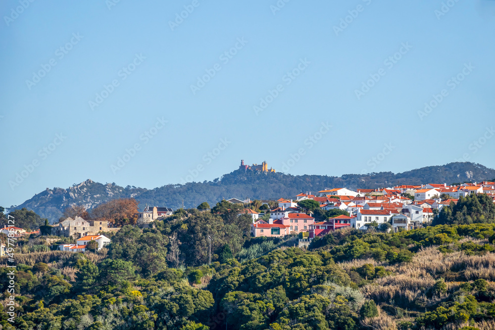 The Pena Palace on the top of a green hill in the Sintra Mountains in a clear day with blue sky, Portugal, Europe