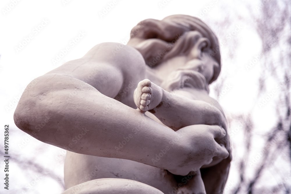 Marble sculpture. A man is holding a baby in his arms.