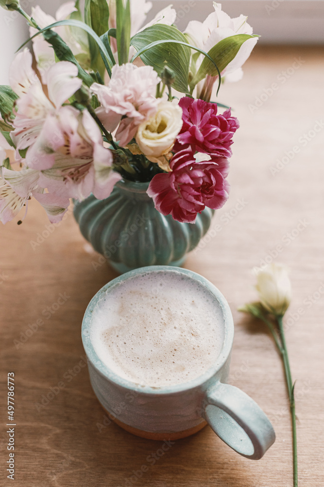 Spring morning aesthetics. Stylish ceramic cup of coffee and flowers on rustic wooden background