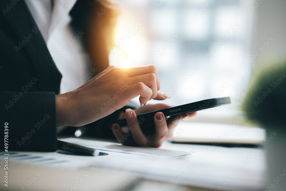young businesswoman looking at financial information from a mobile phone, she is checking company financial documents, she is a female executive of a startup company. Concept of financial management.