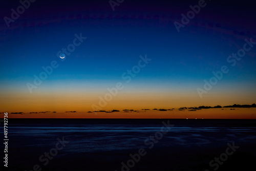 Sunrise with moon over the sea