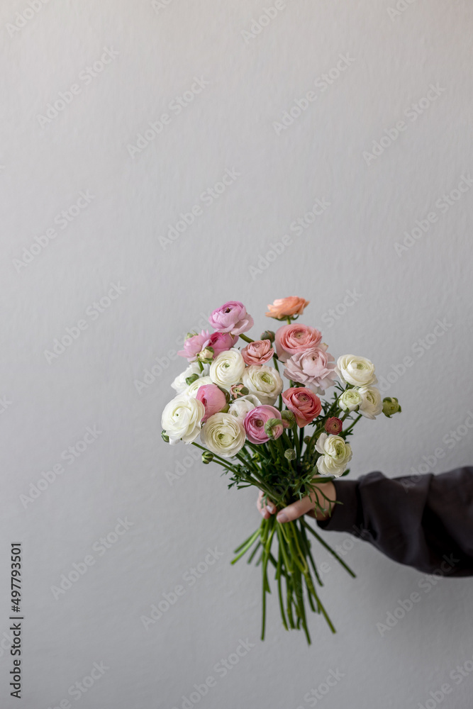 The girl is holding a bouquet of flowers. Ranunculus spring flower. Place for text