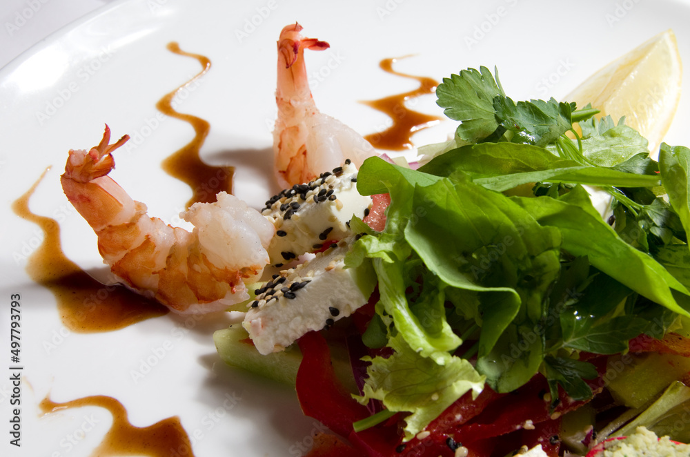 Salad with shrimp, sauce and herbs on a white plate. Selective focus. Salad with shrimp, sauce and herbs on a white plate. Selective focus.