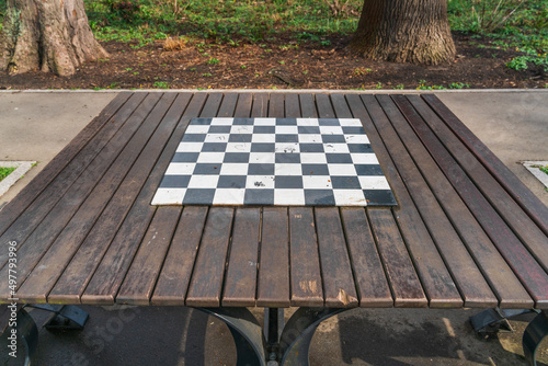 Chessboard on a wooden table in a city park in Krakow, Poland