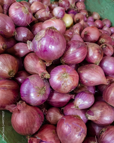 Various onions stacked at a farmers market