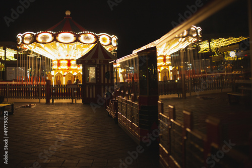 Carousel merry-go-round in the city amusement park at night with motion blur on Christmas fair market on holiday season