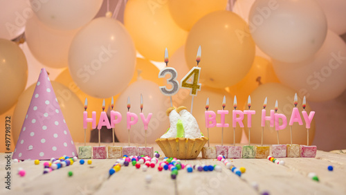 Beautiful background happy birthday number 34 with burning candles, birthday candles pink letters for thirty four years. Festive background with balloons photo