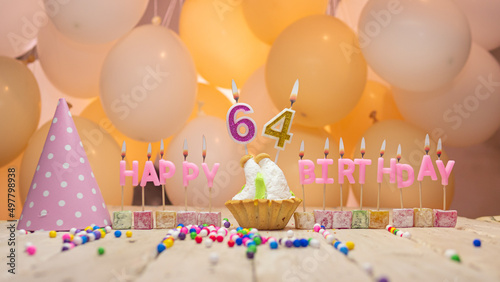 Beautiful background happy birthday number 64 with burning candles, birthday candles pink letters for sixty four years. Festive background with balloons photo