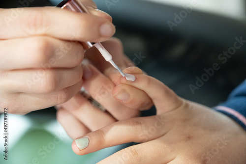 pose de vernis    ongle sur main d enfant