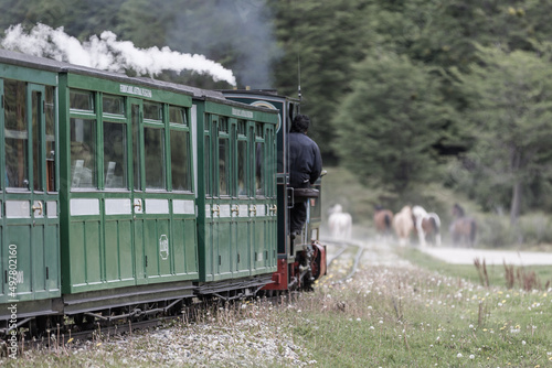 Mit dem südlichsten Zug zum Ende der Welt auf Feuerland, die Dampflok zieht qualmend die grünen Wagons über die alten Bahngleise photo