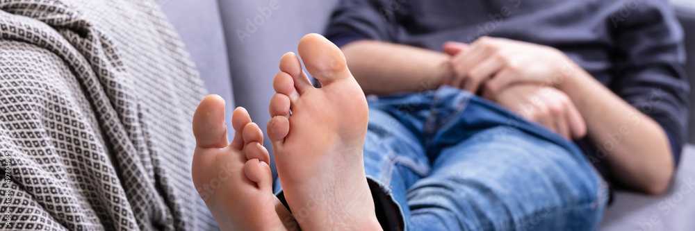 Man Relaxing On Sofa With His Legs Man Relaxing On Sofa With His Legs
