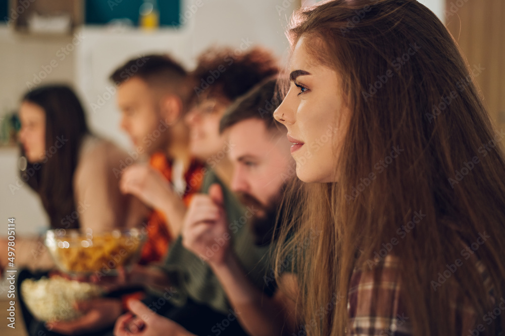 Friends watching movie at home and eating snacks Friends watching movie at home and eating snacks