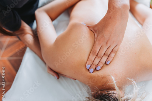 Therapist making winging scapula massage to a female patient. Wellness center spa. Skin care.