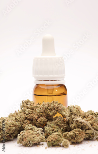 CBD oil with bottle and dropper with buds. brown background. CBD isolated hemp oil. THC-free