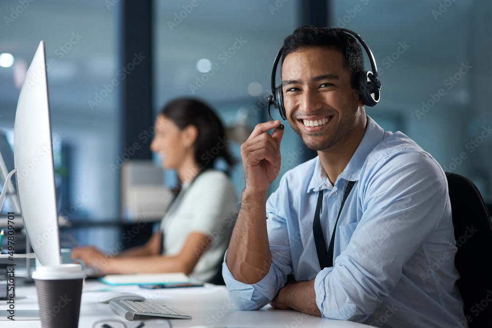 Our customer satisfaction rate says it all. Portrait of a young man using a headset and computer in a modern office. Our customer satisfaction rate says it all. Portrait of a young man using a headset and computer in a modern office.