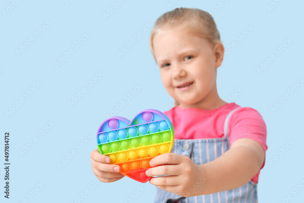 Little girl holding heart shaped pop it fidget toy on color background Little girl holding heart shaped pop it fidget toy on color background