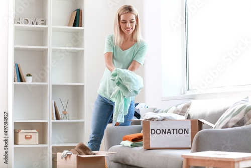 Young woman putting clothes...