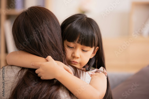Asian Mum her little daughter hugging sit on sofa smile.Loving family portrait, Mothers Day celebration concept .