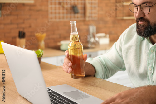Man with laptop drinking be...
