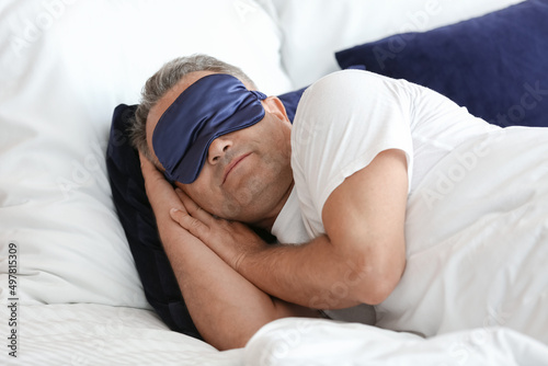 Mature man sleeping in bed