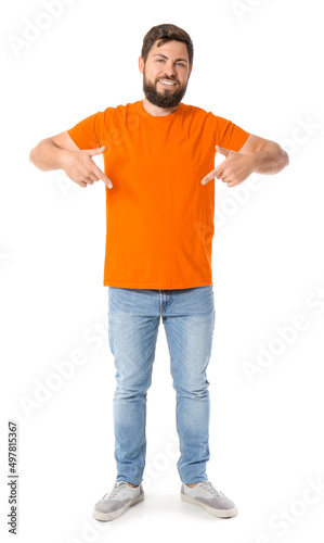 Handsome man pointing at orange t-shirt on white background © Pixel-Shot