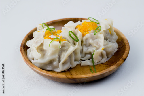 close up of dimsum chinese food. served on a plate with a white background.