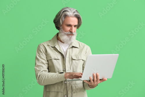 Senior man using laptop on ...