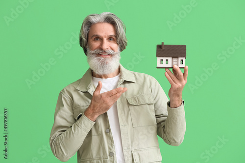 Senior man with house model...