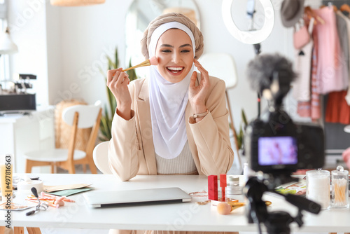 Muslim beauty blogger with brush recording video in dressing room