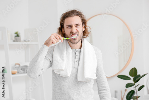 Handsome young man brushing...
