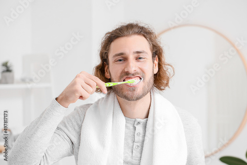 Handsome young man brushing...