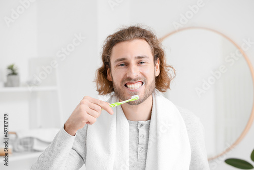 Handsome young man brushing...