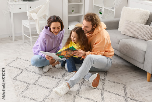 Young family reading book t...