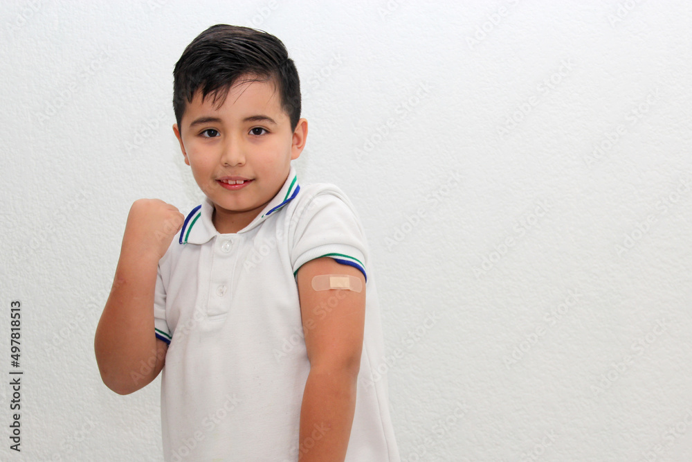 8-year-old Hispanic boy wearing a school uniform shirt happily shows his recently vaccinated arm against Covid-19 in the new normality due to the Coronavirus pandemic
8-year-old Hispanic boy wearing a school uniform shirt happily shows his recently vaccinated arm against Covid-19 in the new normality due to the Coronavirus pandemic
