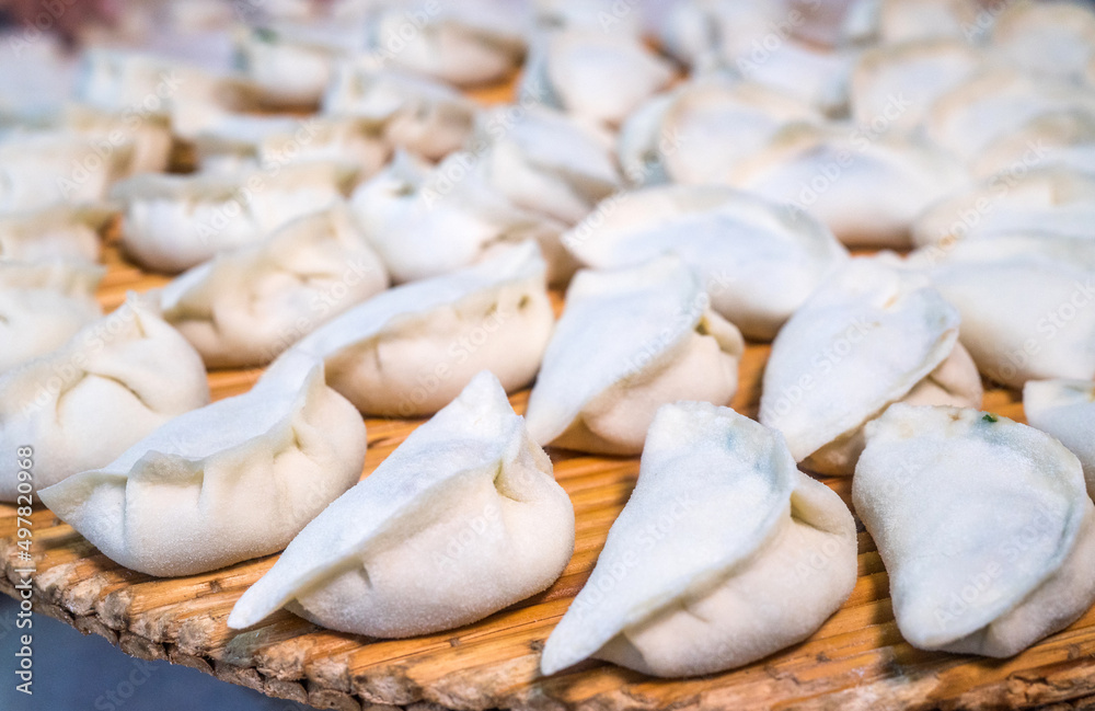 Raw Chinese dumplings on the reed plate ready for steaming Raw Chinese dumplings on the reed plate ready for steaming