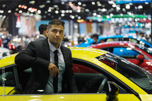 businessman in motor show or car showroom looking for new car to buy © Mongkolchon