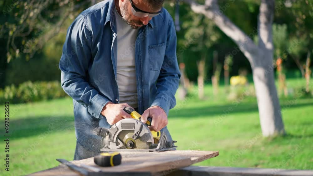 Close-up of craftsman working with circular saw at construction site