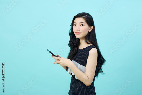 Surprised young Asia lady using mobile phone with positive expre
